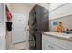 Efficient laundry area showcasing stackable washer/dryer, white cabinets, and a practical sink at 5017 Hanging Moss Ln, Sarasota, FL 34238