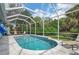 Breathtaking pool area inside lanai, surrounded by lush foliage, creating a private backyard oasis at 5017 Hanging Moss Ln, Sarasota, FL 34238