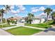 Beautiful home exterior with a well-manicured lawn and stone driveway surrounded by palm trees at 507 Monaco Dr, Punta Gorda, FL 33950