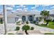Beautiful white home featuring a well manicured front yard with elegant palm trees and stone driveway at 507 Monaco Dr, Punta Gorda, FL 33950