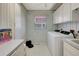 Functional laundry room with modern washer and dryer, ample storage, and a convenient utility sink at 507 Monaco Dr, Punta Gorda, FL 33950