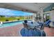 Inviting covered patio with seating area, overlooking a sparkling pool, serene lake, and lush golf course at 507 Monaco Dr, Punta Gorda, FL 33950