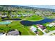 Aerial view of a residential neighborhood, featuring well-manicured lawns, pond, and golfing at 61 Caddy Rd, Rotonda West, FL 33947