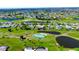 Panoramic aerial view of a residential neighborhood surrounded by a lush golf course, with ponds and well-maintained landscaping at 61 Caddy Rd, Rotonda West, FL 33947