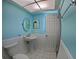 Bathroom with pedestal sink, paneled walls, and tile flooring at 61 Caddy Rd, Rotonda West, FL 33947