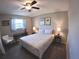 Bedroom with ceiling fan, bedside tables, and palm tree art on the walls at 61 Caddy Rd, Rotonda West, FL 33947