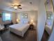 Bedroom with ceiling fan, bedside tables, a mirror, and palm tree art at 61 Caddy Rd, Rotonda West, FL 33947
