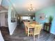 Bright dining area featuring wood-look tile floors, modern chandelier, and an open floor plan at 61 Caddy Rd, Rotonda West, FL 33947