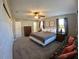 Large bedroom with ceiling fan, two windows, and a sitting area with floral pattern couch at 61 Caddy Rd, Rotonda West, FL 33947