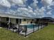 Pool area surrounded by black fencing, with comfortable seating and a grill at 61 Caddy Rd, Rotonda West, FL 33947
