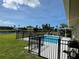 Backyard pool features a black aluminum fence, canals in the background, and a grill on the patio at 61 Caddy Rd, Rotonda West, FL 33947