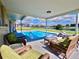 Enjoy outdoor living with this pool, featuring a covered patio and serene water views at 61 Caddy Rd, Rotonda West, FL 33947
