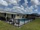 Backyard pool surrounded by a black fence and comfortable seating area at 61 Caddy Rd, Rotonda West, FL 33947