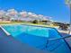 Large, sparkling in-ground pool, ideal for enjoying the outdoors and soaking up the sun, waterfront in the background at 61 Caddy Rd, Rotonda West, FL 33947