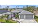 Charming home showing meticulously kept landscaping, paver driveway, and a two-car garage at 664 Rotonda Cir, Rotonda West, FL 33947