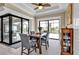 Bright dining room with a square wood table, four upholstered chairs, and doors to an outdoor pool area at 664 Rotonda Cir, Rotonda West, FL 33947