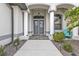 Charming home showing a covered doorway and paver walkway that's flanked by garden beds and coach lights at 664 Rotonda Cir, Rotonda West, FL 33947