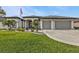 Beautiful home showcasing a manicured lawn, fresh landscaping, and a two-car garage at 664 Rotonda Cir, Rotonda West, FL 33947