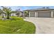 Charming home showing meticulously kept landscaping, fresh lawn, and a two-car garage at 664 Rotonda Cir, Rotonda West, FL 33947