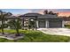 Stunning home showcasing a manicured lawn, fresh landscaping, and a two-car garage at 664 Rotonda Cir, Rotonda West, FL 33947