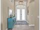 Welcoming foyer highlighting an accent table, decorative mirror, wood-look floors, and a double door entrance at 664 Rotonda Cir, Rotonda West, FL 33947