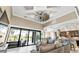 Bright, open living area with a decorative windmill ceiling fan, large windows, and view of the screened pool area at 664 Rotonda Cir, Rotonda West, FL 33947