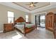 Spacious main bedroom with wood-look floors, a ceiling fan, and access to the screened lanai at 664 Rotonda Cir, Rotonda West, FL 33947