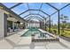 Relaxing screened pool area with a spillover spa, ample patio space, and lush landscaping at 664 Rotonda Cir, Rotonda West, FL 33947