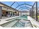 Inviting pool and spa featuring a screened enclosure, outdoor kitchen, and outdoor living room at 664 Rotonda Cir, Rotonda West, FL 33947
