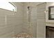 Custom tiled shower with a pebble floor and a window for natural light at 664 Rotonda Cir, Rotonda West, FL 33947