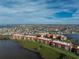 Aerial view of waterfront condos featuring grassy lawns, lake, and lush landscaping at 87 Vivante Blvd # 8732, Punta Gorda, FL 33950