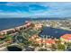 An aerial view of waterfront condos with a pool, tennis court, and lake views at 87 Vivante Blvd # 8732, Punta Gorda, FL 33950
