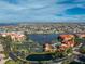 Aerial view of waterfront condos featuring tennis courts, lake, and lush landscaping at 87 Vivante Blvd # 8732, Punta Gorda, FL 33950