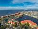 An aerial view of waterfront condos with a pool, tennis court, and lake views at 87 Vivante Blvd # 8732, Punta Gorda, FL 33950