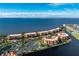 Stunning aerial view of waterfront condos, lush landscaping, tennis courts, and picturesque ocean views at 87 Vivante Blvd # 8732, Punta Gorda, FL 33950