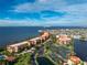 An aerial view of waterfront condos with a pool, tennis court, and lake views at 87 Vivante Blvd # 8732, Punta Gorda, FL 33950