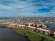 Aerial view of waterfront condos featuring grassy lawns, lake, and lush landscaping at 87 Vivante Blvd # 8732, Punta Gorda, FL 33950