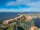 An aerial view of waterfront condos with a pool, tennis court, and lake views at 87 Vivante Blvd # 8732, Punta Gorda, FL 33950