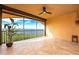 A screened balcony with a ceiling fan overlooks a scenic water view with travertine tile flooring and lots of natural light at 87 Vivante Blvd # 8732, Punta Gorda, FL 33950