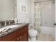Well-lit bathroom features granite counters, decorative print, and shower-tub with curtain at 87 Vivante Blvd # 8732, Punta Gorda, FL 33950