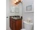 Charming bathroom featuring cherry wood vanity, granite counter, and decorative shell artwork at 87 Vivante Blvd # 8732, Punta Gorda, FL 33950