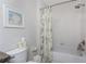 Bright bathroom featuring white shower-tub, decorative print, and toilet with accessories at 87 Vivante Blvd # 8732, Punta Gorda, FL 33950