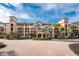 Luxury mid-rise condo building featuring a brick circular driveway, tropical landscaping and a stucco facade at 87 Vivante Blvd # 8732, Punta Gorda, FL 33950