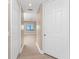 Bright hallway leads to a bedroom with a ceiling fan and large window at 87 Vivante Blvd # 8732, Punta Gorda, FL 33950