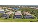 Aerial view of screened-in pools, tropical landscaping, and a serene lake in a residential neighborhood at 12905 N Marsh Dr, Port Charlotte, FL 33953