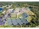Aerial view of community center with tennis courts, pool, lawn bowling, and parking at 12905 N Marsh Dr, Port Charlotte, FL 33953