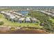 Scenic aerial view of screened-in pools, tropical landscaping, and a serene lake in a residential neighborhood at 12905 N Marsh Dr, Port Charlotte, FL 33953