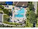 Top-down view of a uniquely shaped community pool featuring lap lanes, sunbathing areas, and ample shaded seating at 12905 N Marsh Dr, Port Charlotte, FL 33953