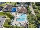 Overhead shot of community pool area with shaded seating, umbrellas, palm trees and recreational swimming at 12905 N Marsh Dr, Port Charlotte, FL 33953