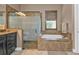 Bathroom featuring a soaking tub, tiled surround, and separate shower at 12905 N Marsh Dr, Port Charlotte, FL 33953